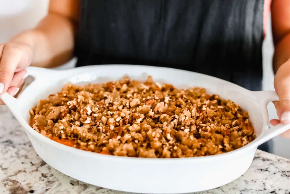 The best sweet potato casserole is smooth and creamy, sprinkled with a brown sugar pecan mixture. It's a sweet and savory side dish that is perfect for the holidays! Brown sugar pecan mixture added to casserole.