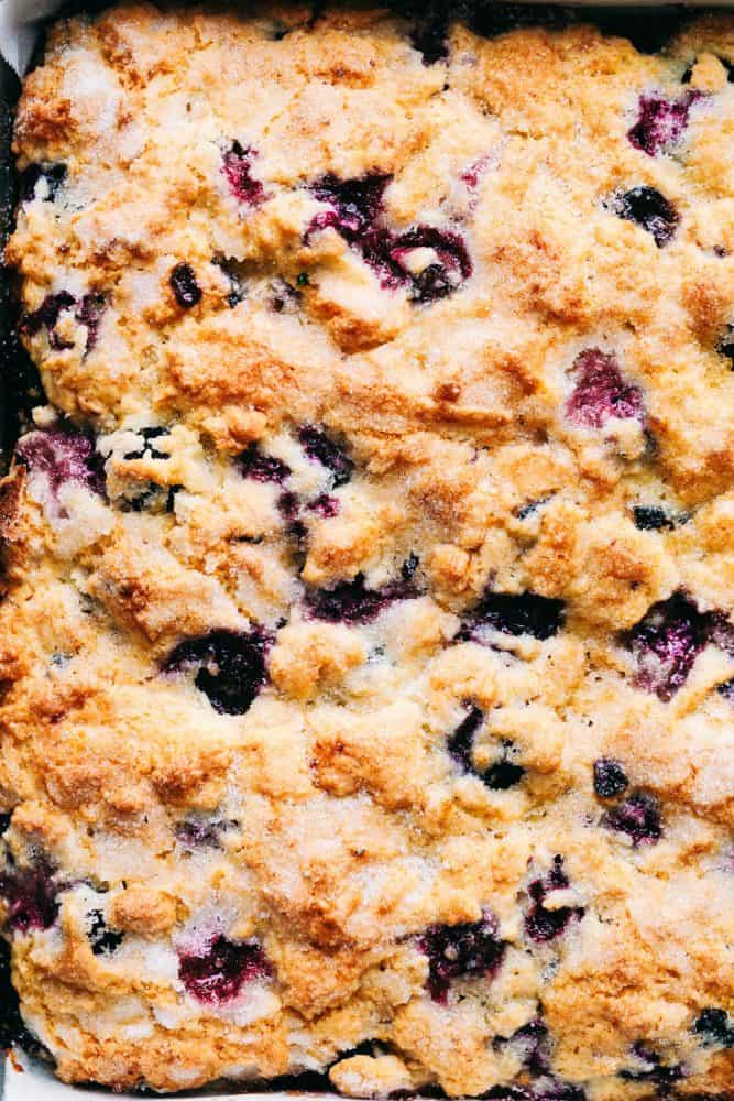 Blueberry buttermilk breakfast cake is so easy to throw together for breakfast. It is incredibly moist, buttery, and bursting with fresh blueberries inside. One piece is never enough! Top-down view of blueberry buttermilk breakfast cake.