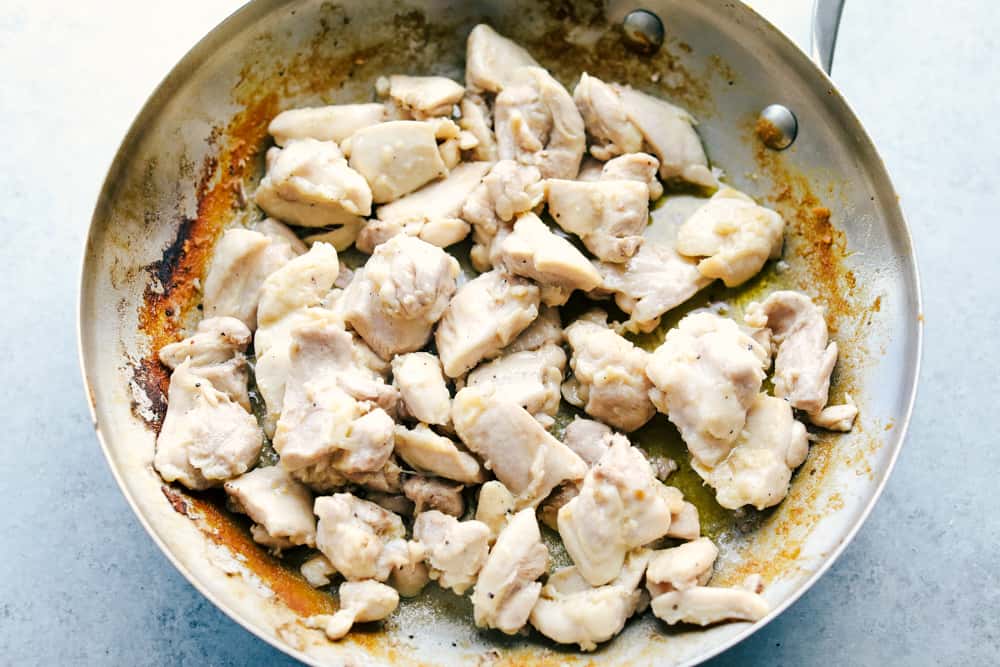 Best Bourbon Chicken is juicy, tender chicken thighs cut into pieces simmered in a sweet, brown sugar glaze that will melt in your mouth. Rich in flavor and served over rice for a complete meal! chicken cooking in a skillet