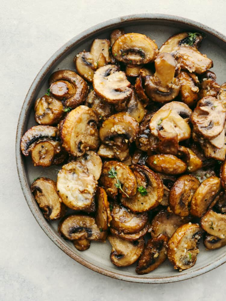 Confession: I never thought I liked mushrooms… until I made these air fryer mushrooms. With garlic parmesan, they’re juicy, tender, and downright addictive. Even the mushroom skeptics at your table will be fighting over the last bite! Top-down view of garlic parmesan air fryer mushrooms on a gray plate.